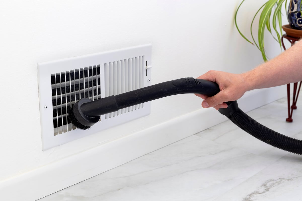 Professional technician cleaning air duct